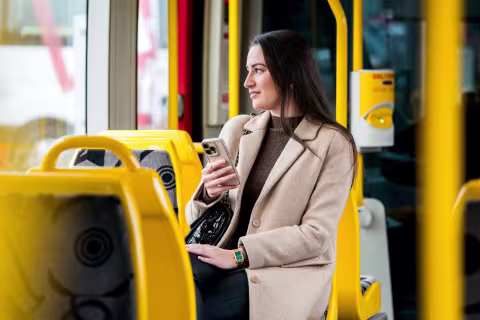 Femme avec un téléphone dans la main dans un tram Soléa