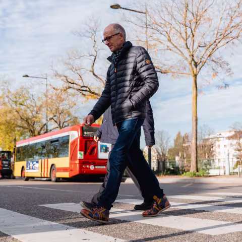 Piétons qui traversent la route au passage piéton avec un bus Soléa en arrière plan
